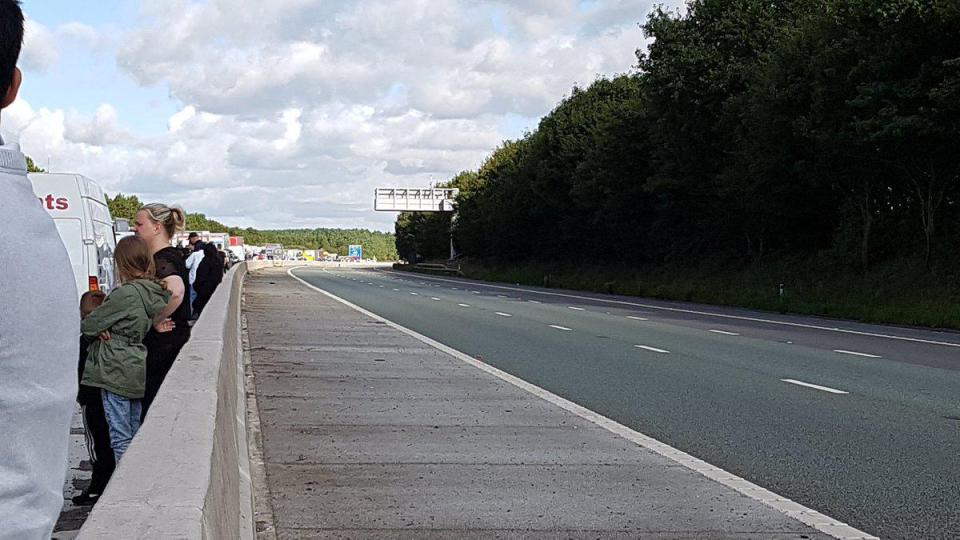  Hundreds of fed up motorists and passengers waited outside their cars, with police warning the road could be closed until 6pm