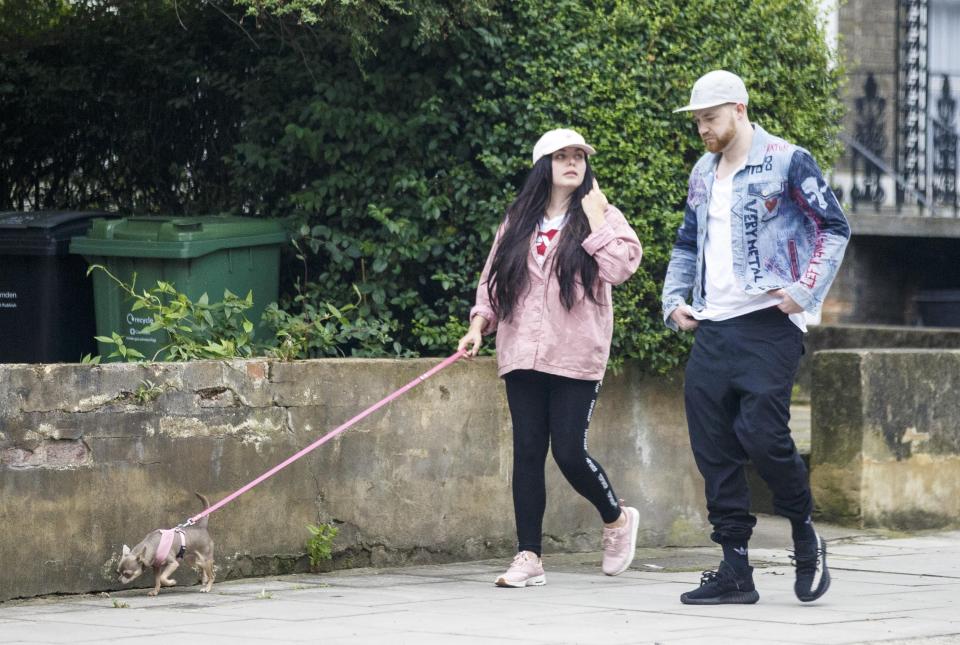  Scarlett and Luke wear similar outfits as they walk their tiny dog