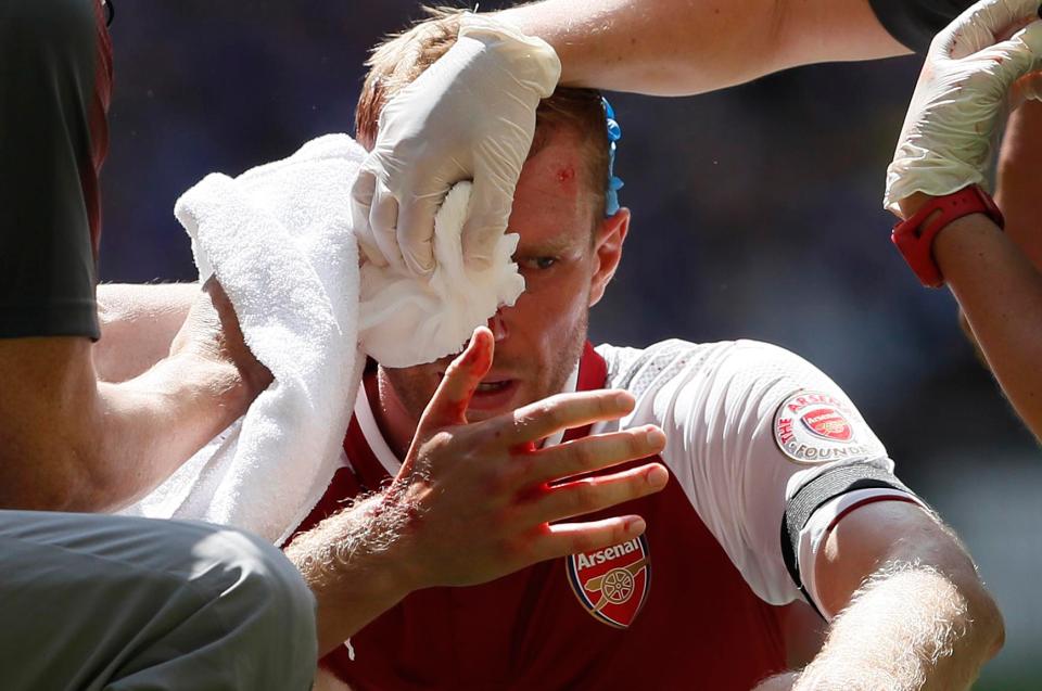  Per Mertesacker was forced off early in the first half after he was cut open by Gary Cahill's elbow