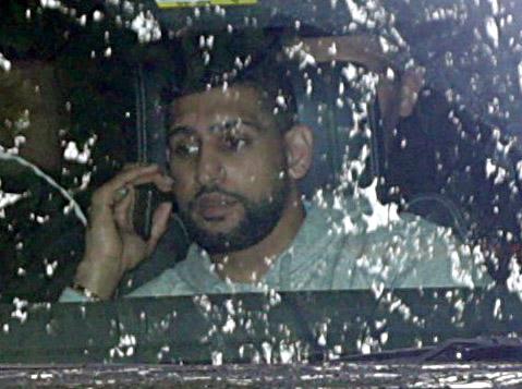  Amir Khan speaks on the phone as he visits the family home yesterday after flying back from Dubai