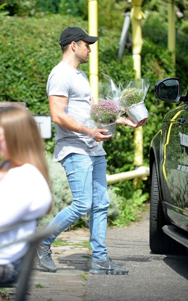 Mark was the doting husband, carrying some potted plants to the car for Michelle