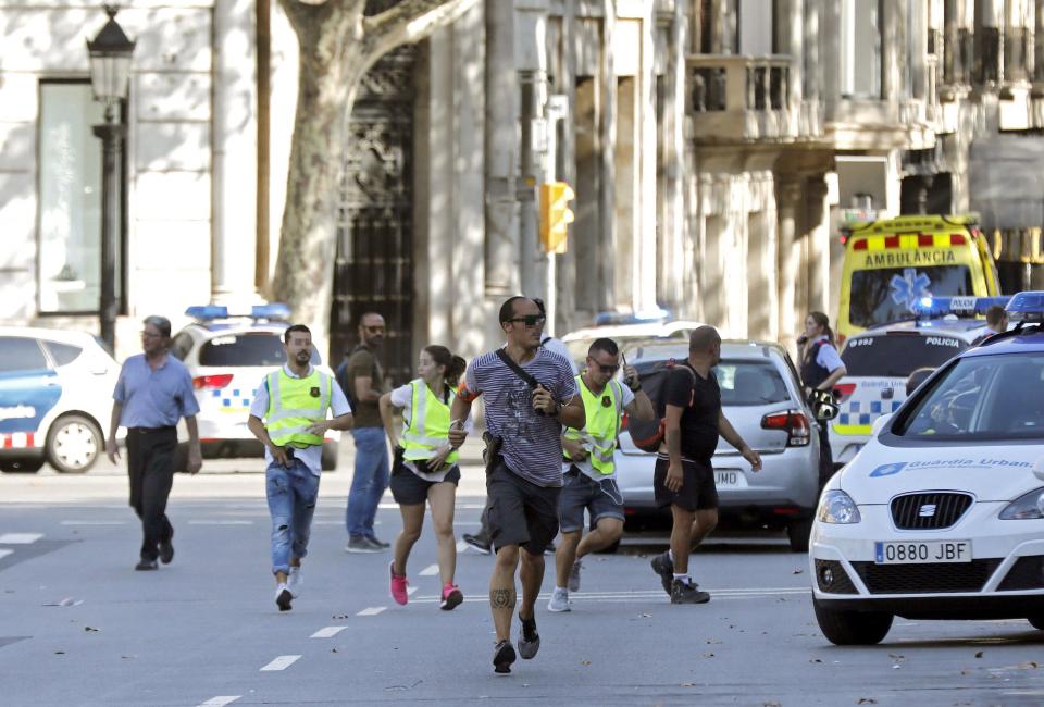  Panicked people are pictured running through the streets of the Catalan capital