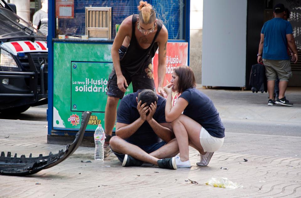  A grief-stricken witness is comforted by friends amid the horror in Barcelona