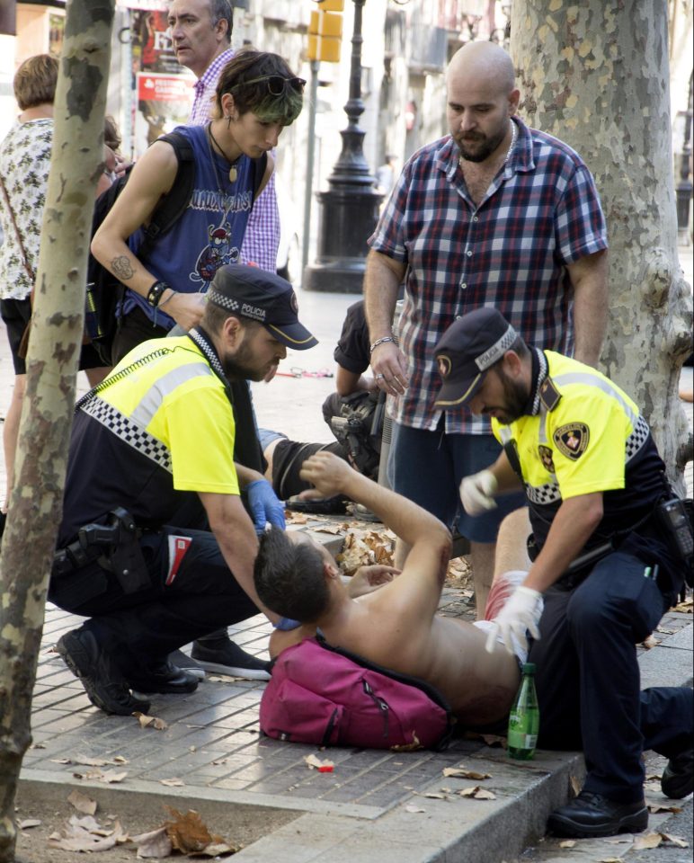  A man is given medical treatment on the ground by emergency workers