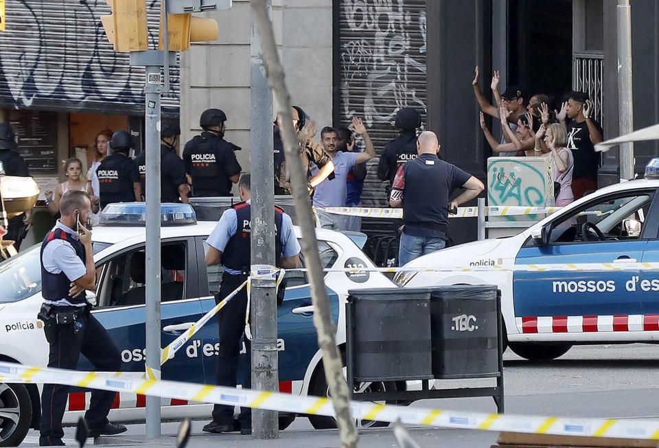  Scared people pictured with their arms raised being evacuated from the area following the van assault