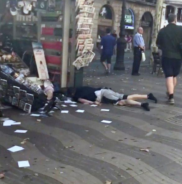  Another victim is pictured lying face down next to a news stand in the busy area of the city