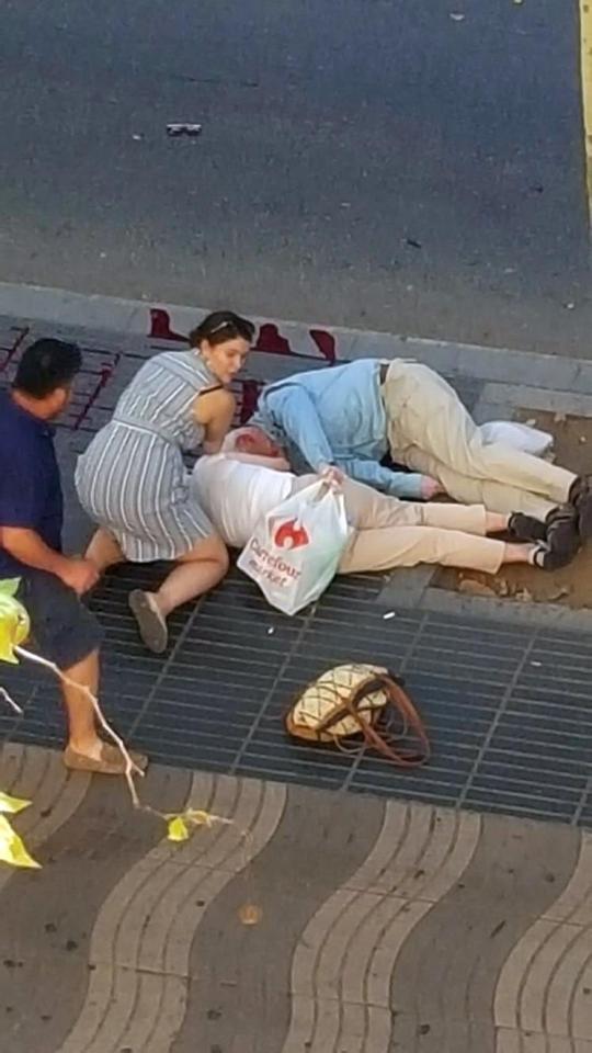  A woman helps the injured at the scene of a terror attack in Barcelona