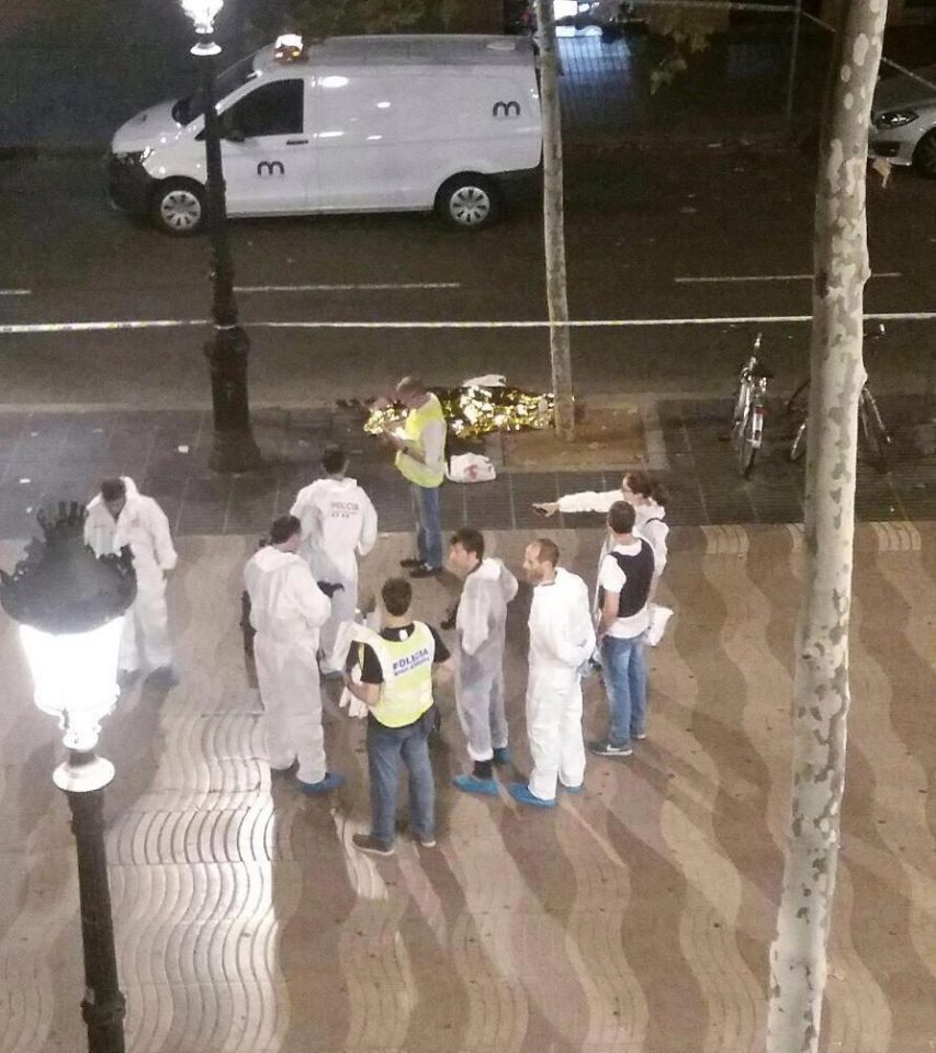  Emergency workers pictured near a dead body in the Spanish city