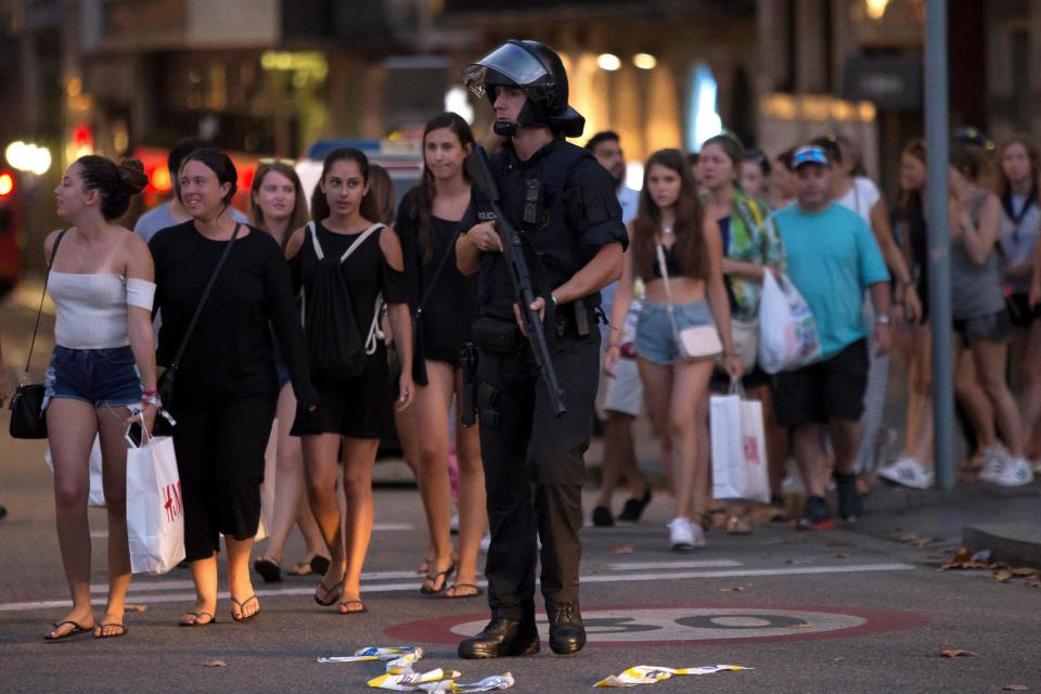  An armed officer pictured beside dozens of people near the scene of the attack in Barcelona