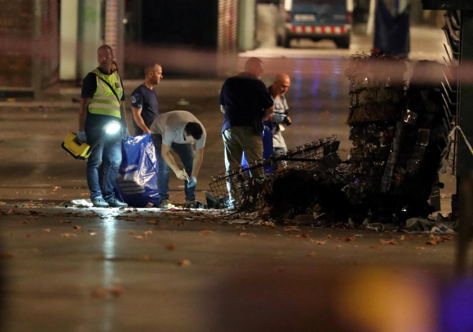  Forensic police officers search for clues near the area where the van attack took place