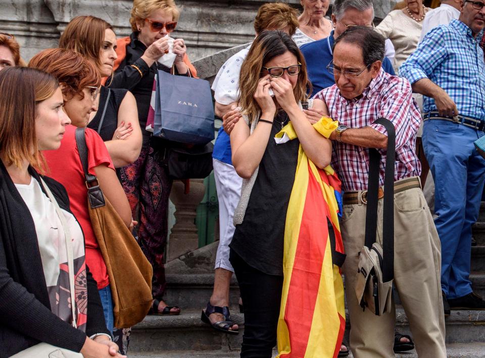  A woman clutching a Spanish flag cries at the scene of the terror attack today