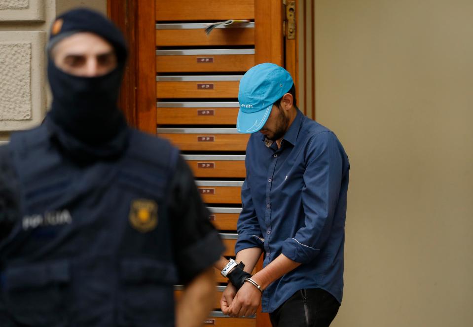  A suspect is led out of a building by police in Ripoll, north of Barcelona