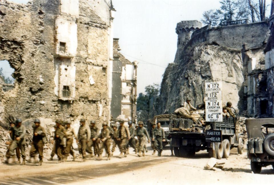  A sign erected in the devastated ruins of Saint-Lo directs troops