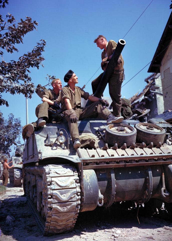  These Canadian troops enjoy a pause in hostilities underneath a cloudless sky before they head towards Caen