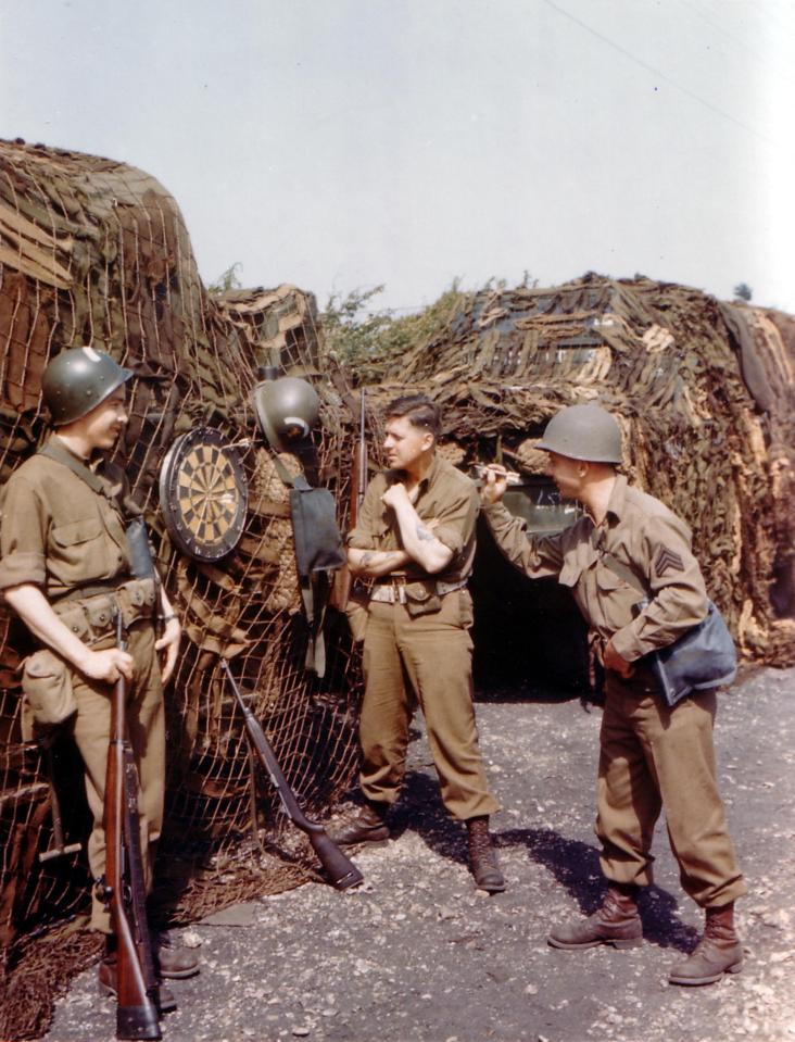  GIs enjoy a game of darts and share a joke as they wait to board boats heading to Normandy