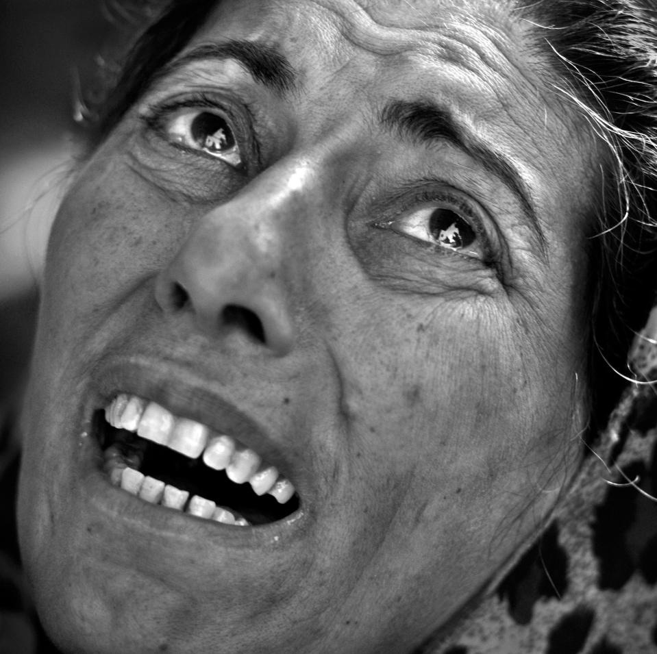  A woman weeps about many family members buried under the rubble of her home still praying they can be rescued