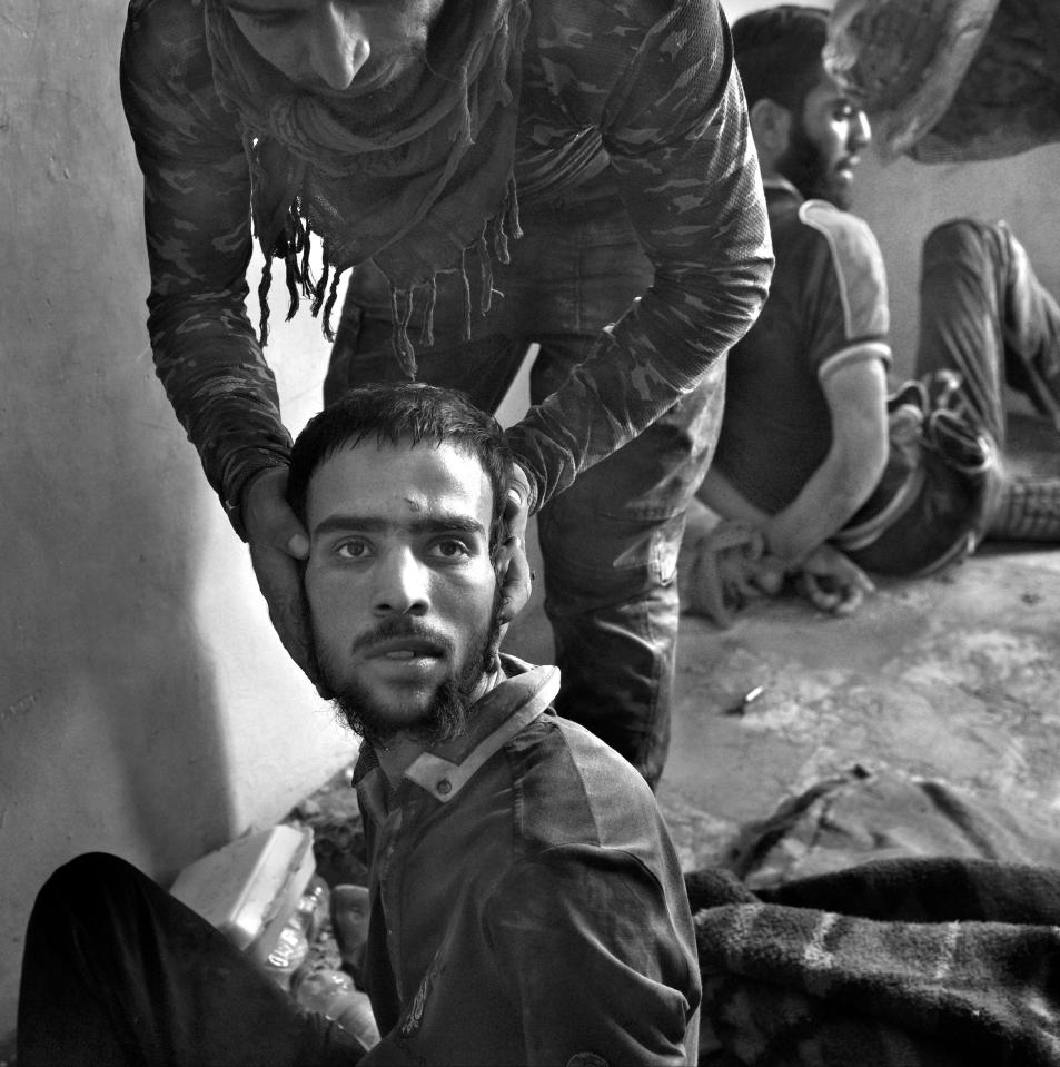  A soldier shows the face and beard of a suspected ISIS fighter that surrendered after being surrounded by ISOF Special Forces in West Mosul amid ruins of the city. They say they are not ISIS. They are held captive at a base near the front line.