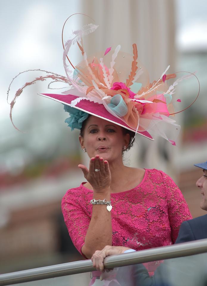  A cheery racegoer blows a kiss at the waiting photographers as the first race of the day gets underway