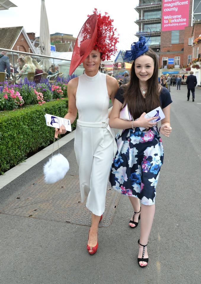  One glam racegoer stunned in a cream midi dress and red hat, while her pal looked chic in a floral navy dress