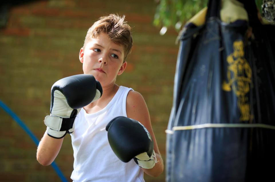  Johnny practices his boxing skills on a punch bag in the garden