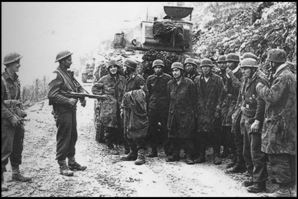  Prisoners are guarded by soldiers of the 2nd NZ Division behind a Sherman tank