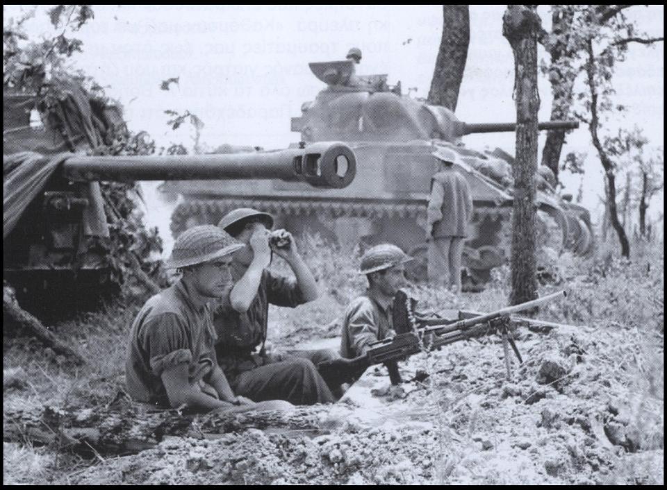  The crew of a British machine gun, a 17-pounder (76.2-mm) antitank gun, and a Sherman tank waiting for the attack order