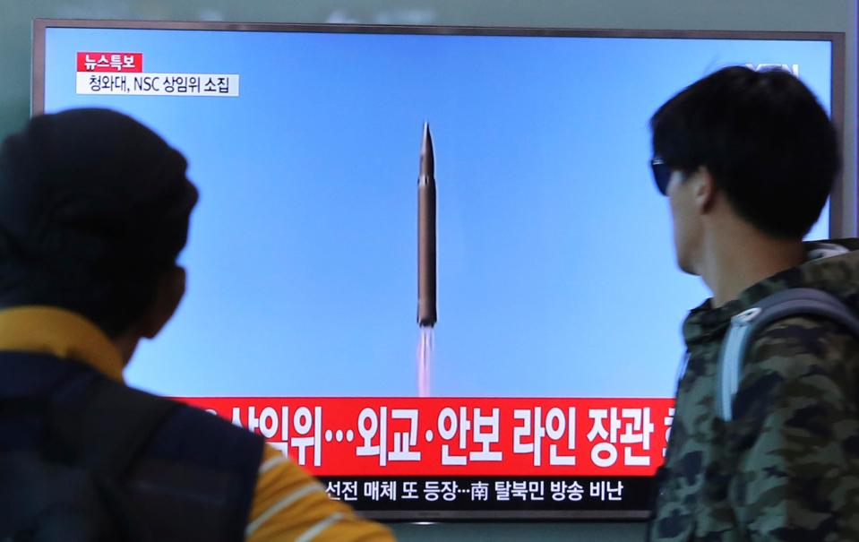  People watch a TV screen showing a file footage of North Korea's missile launch