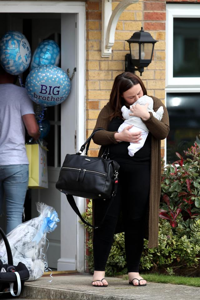  Chanelle looked besotted with their new arrival as she snuggled him on the front doorstep