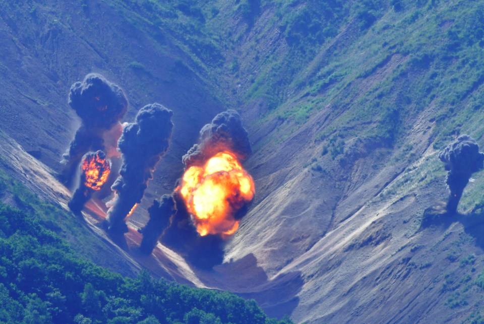 Explosions erupt on the mountain landscape after being peppered by the munitions