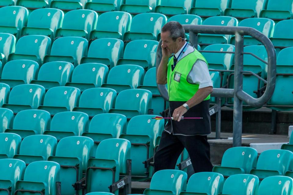  An arrow which was shot onto the pitch is carried by a steward at the oval