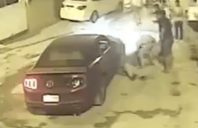  Friends and pedestrians rush to help the man as he lay by the car