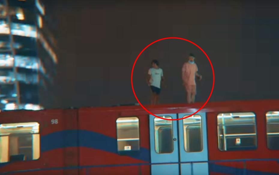  Two pranksters riding on top of a DLR train before jumping into the River Thames