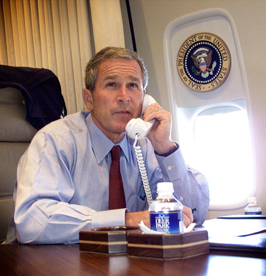  George W Bush watches television as he talks on the phone with New York Mayor Rudy Guiliani and Gov. George Pataki aboard Air Force One