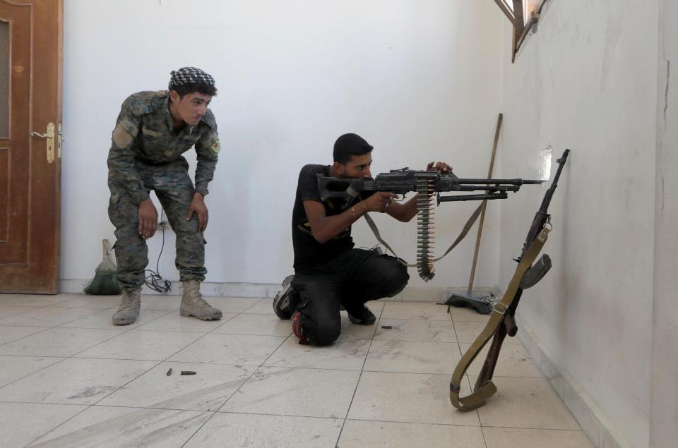  A member of the Syrian Democratic Forces aims his weapon as he prepares for an oncoming attack during the fighting with Islamic State's fighters in the old city of Raqqa