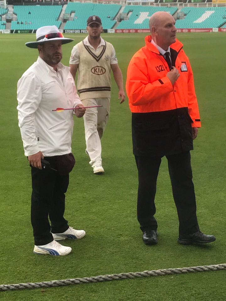  One of the umpires holding the bolt after play was suspended