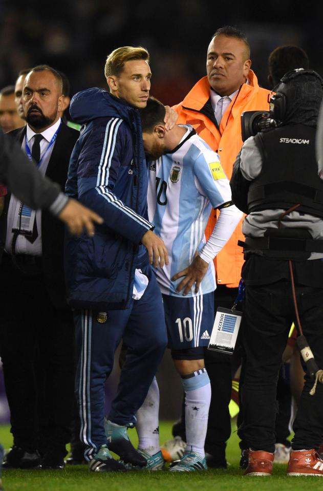  Lionel Messi is consoled by a coach after the final whistle in Buenos Aires