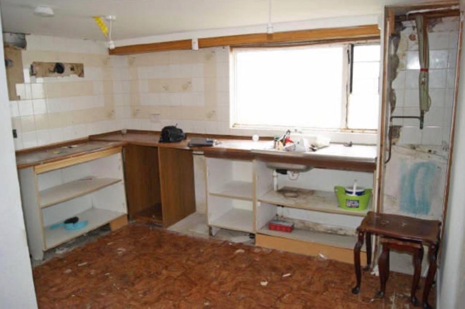  The cupboards have been pulled off the walls in the bare kitchen