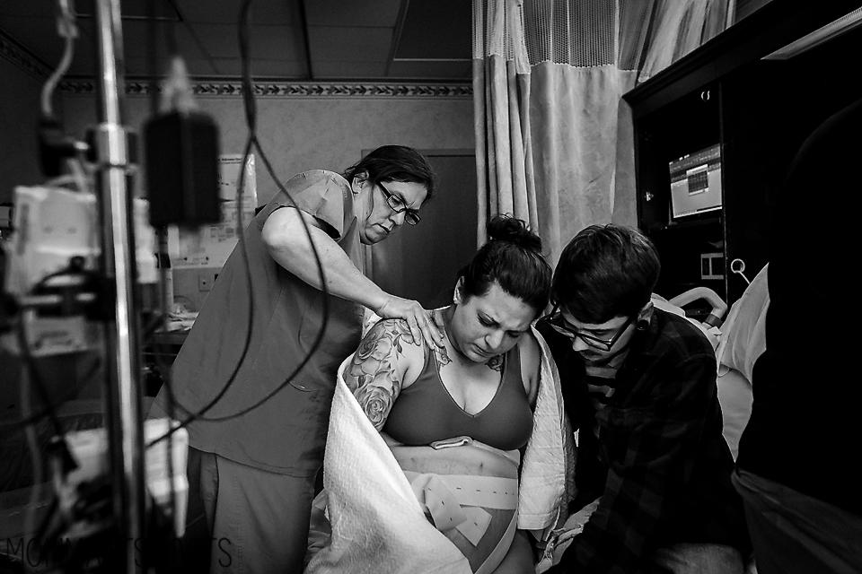  Her a nurse massages a pregnant woman's back as she and her partner await the arrival of their baby