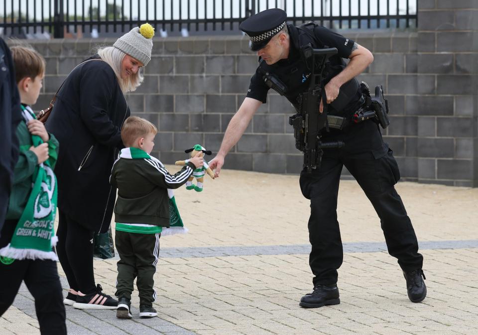  An officer interacts with a young football fan outside Celtic Park