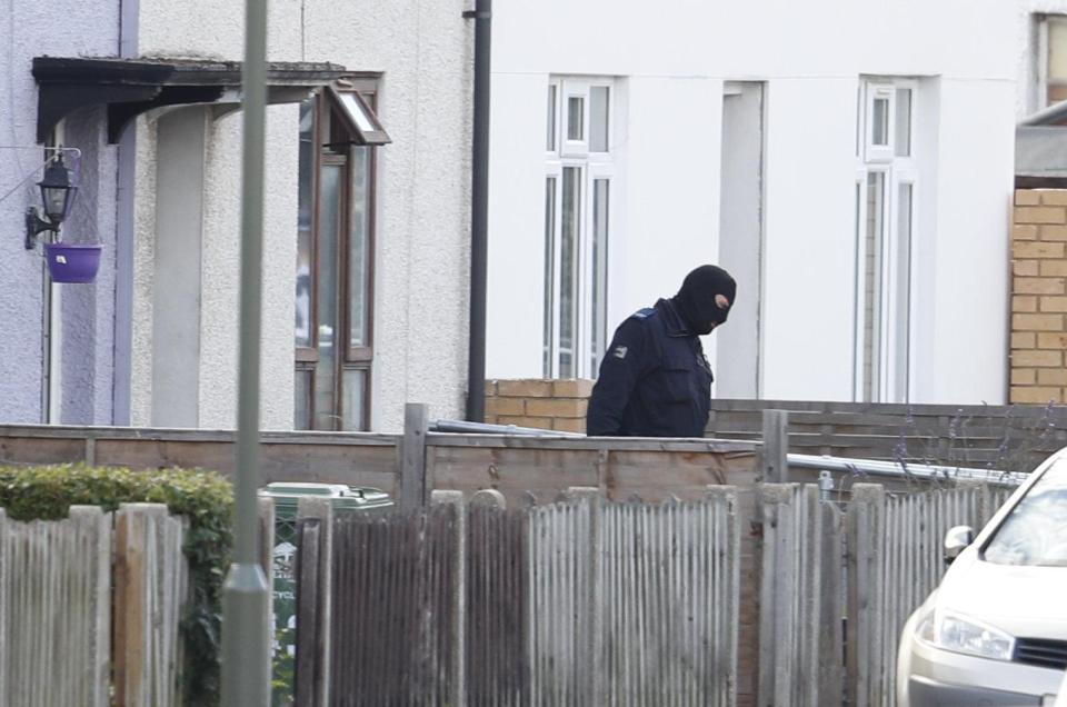  Masked officers have been seen coming from a house on the quiet cul-de-sac