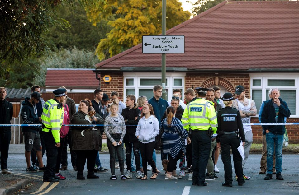  Onlookers watch as police conduct a raid on a property on Cavendish Road