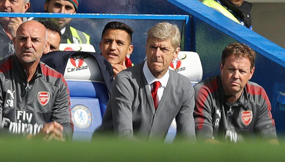  Alexis Sanchez sits behind Arsene Wenger at Stamford Bridge