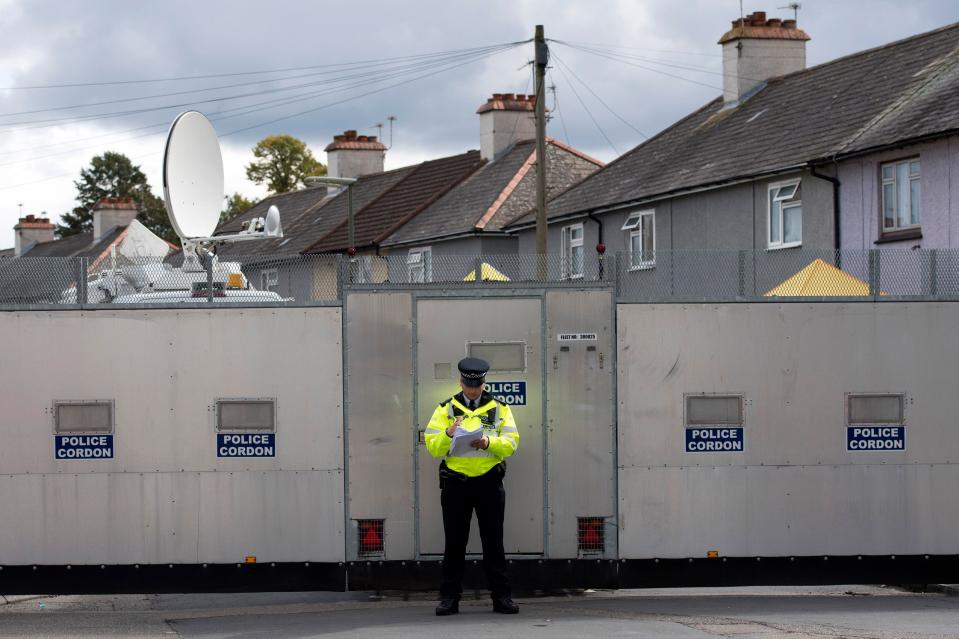  A police officer stood by a barrier cordon outside an address in Sunbury-upon-Thames, Surrey