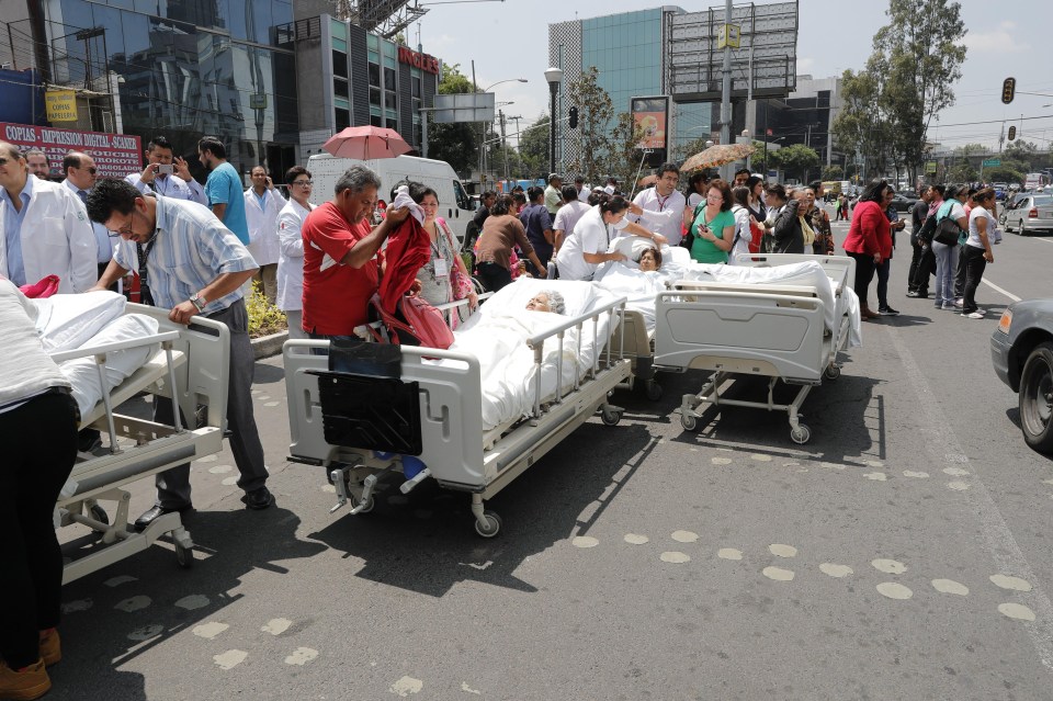 People receive treatment on the street outside a hospital after the quake 