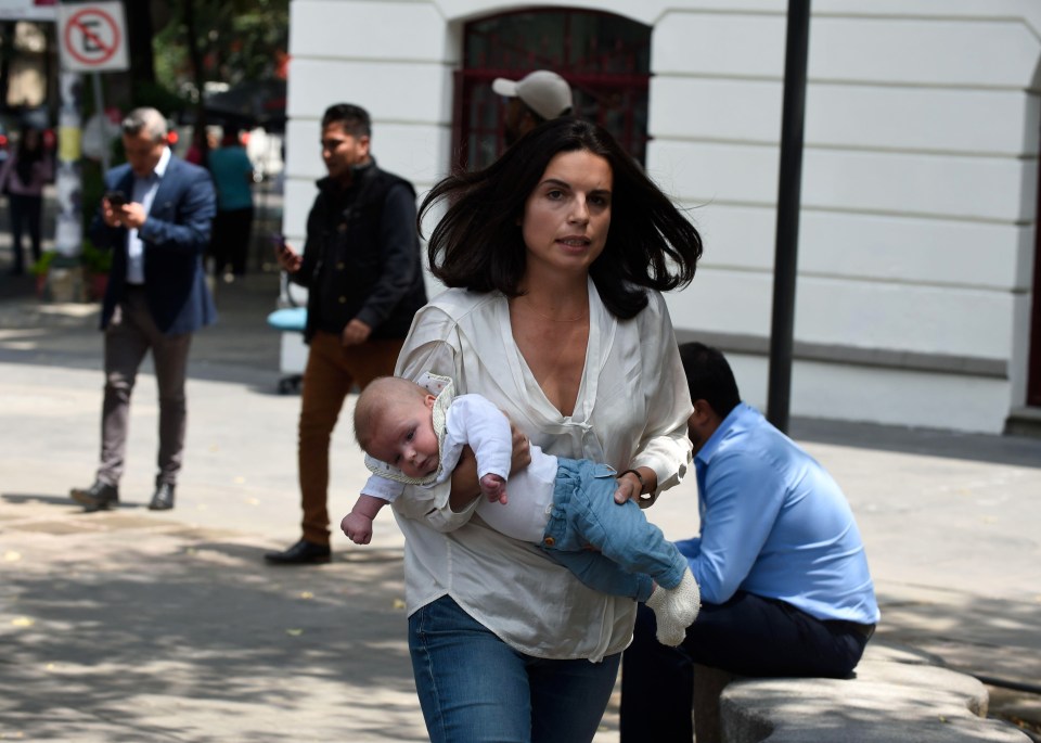 A woman flees to safety with her baby along the streets of Mexico City 