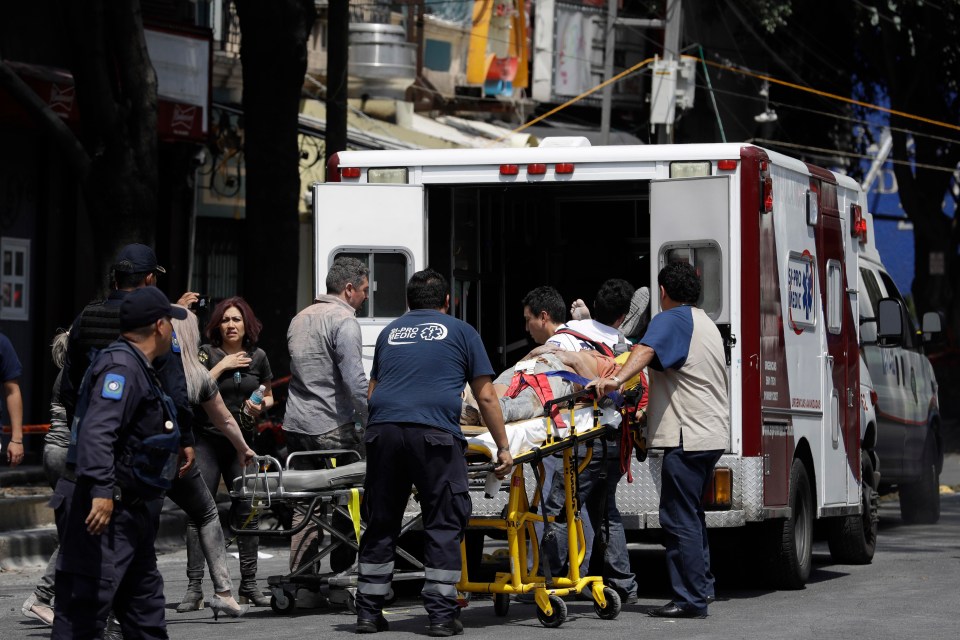 Emergency services lead the injured into a back of an ambulance for treatment 