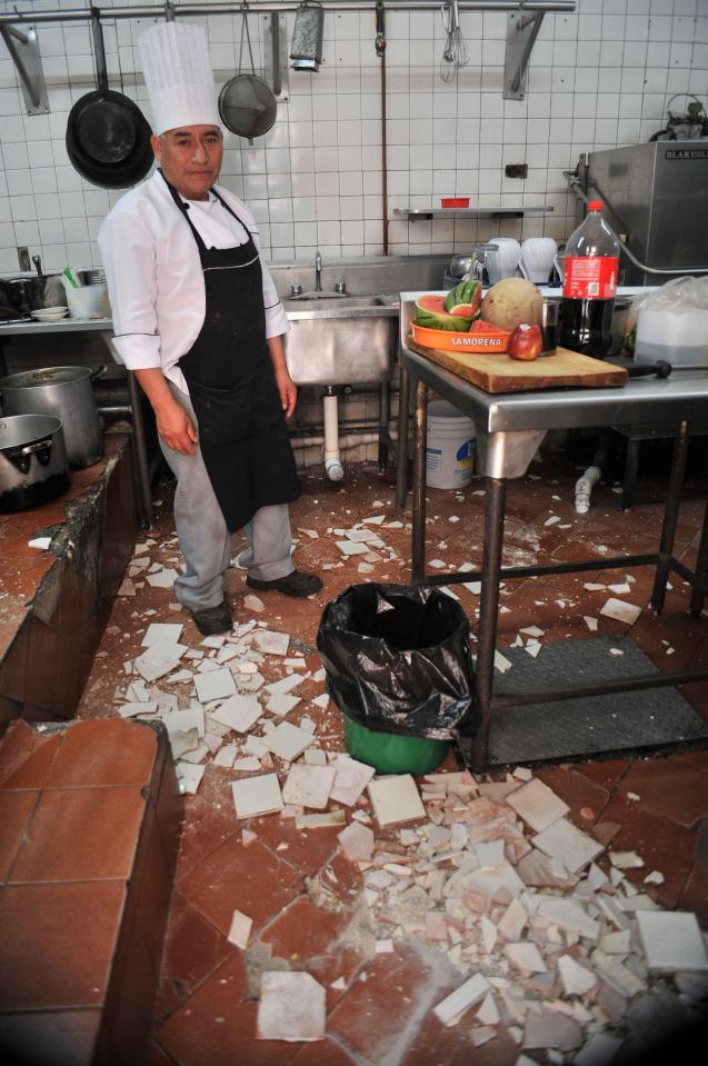  A chef stands beside the damage caused by the damage caused in his kitchen at a restaurant