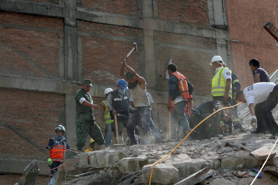 People begin to smash the rubble in a bid to find survivors 