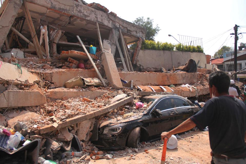  A car is seen flattened underneath the collapsed Enrique Rebsamen elementary school