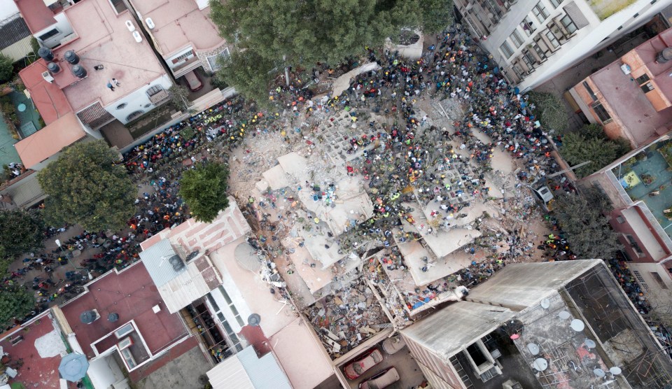 Rescue efforts continue as people desperately try to rescue those trapped under collapsed buildings